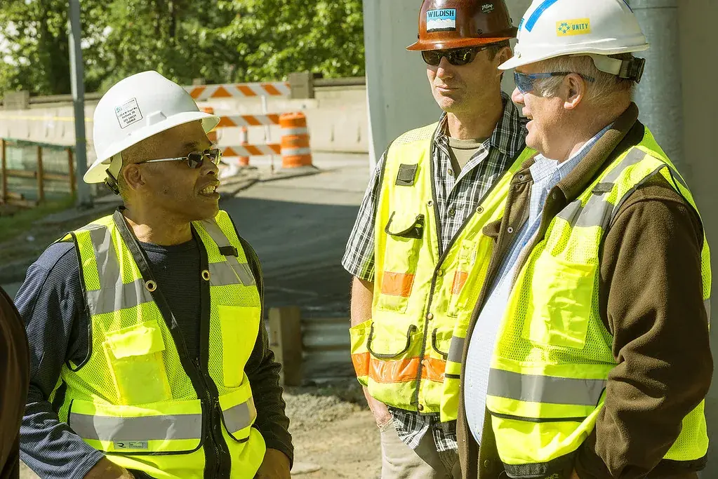 Site workers wearing hard hats and high-visibility vests