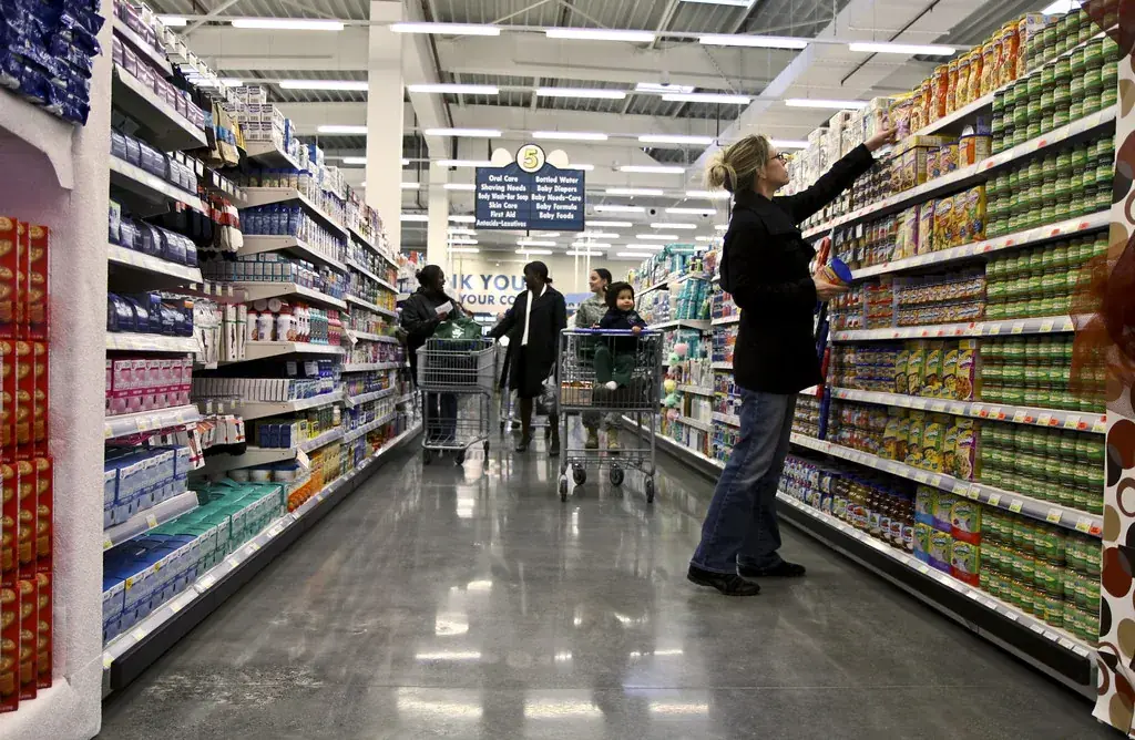 Shoppers with trolleys in a supermarket aisle