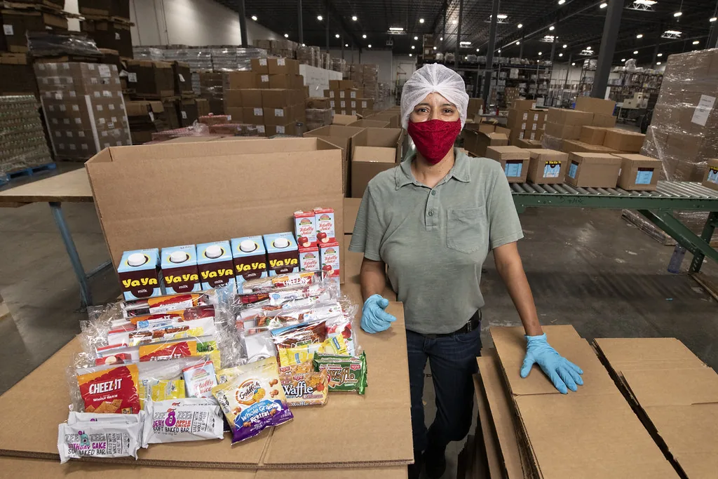 Warehouse worker handling stacked boxes of goods